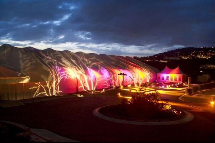 large tent outside lit by colored lights